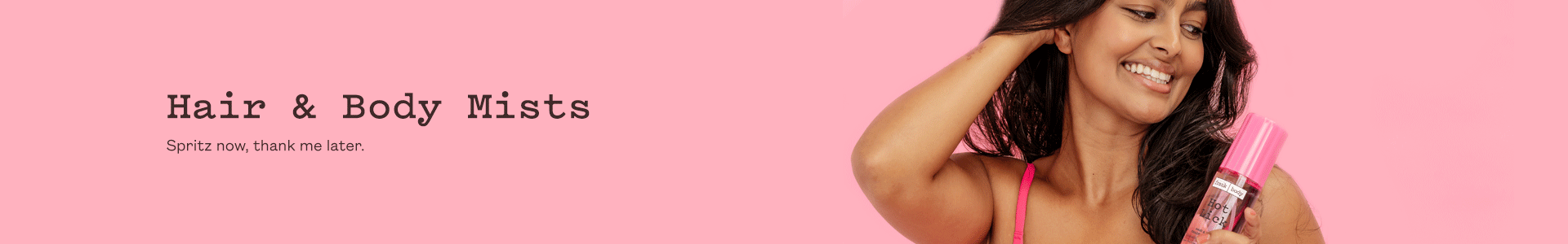 Hair and Body Fragrance Mists category banner: a smiling woman in a hot pink bra runs a hand through her hair while holding a pink frank body mist bottle. Text reads: Hair & Body Mists. Spritz now, thank me later.