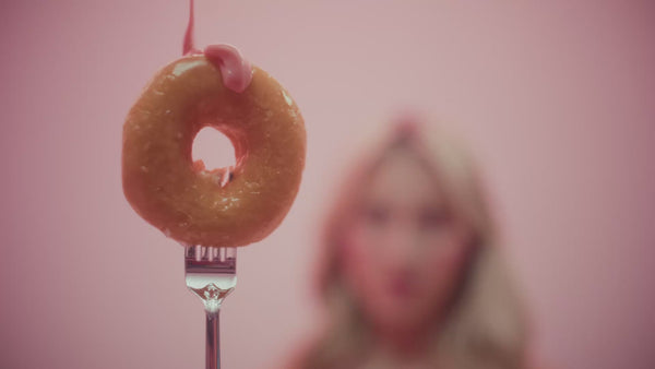 frank body Glazed Buns gift set video: a model unboxes the kit and applies Firming Body Glaze and Firming Body Cream against a pink backdrop.